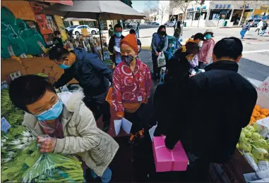  ?? PHOTOS BY PJOSE CARLOS FAJARDO — STAFF PHOTOGRAPH­ER ?? Compassion in Oakland volunteer Tiffany Lin, center, walks past shoppers on Eighth Street while patrolling Chinatown in Oakland on Saturday. Lin and others are acting as security escorts and providing extra sets of eyes and ears on crime.