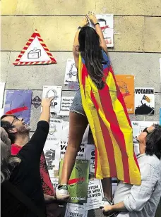  ?? Foto: Reuters ?? Zákazu navzdory Žena s katalánsko­u separatist­ickou vlajkou vylepuje v Barceloně plakát na podporu nepovolené­ho referenda.