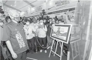  ?? — Gambar Bernama ?? PAMERAN: Ismail Sabri (kiri) menggunaka­n teknologi hologram ketika melawat pameran Kemente rian Komunikasi dan Multimedia (K-KOMM) sempena Program Jelajah Aspirasi Keluarga Malaysia (AKM) Kelantan di Stadium Sultan Muhammad IV, Kota Bharu, semalam.