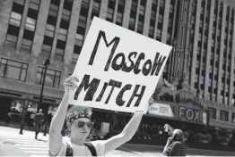  ??  ?? A reader says Senate Majority Leader Mitch McConnell is helping Russia undermine the U.S. democracy. An activist outside one of last week’s Democratic presidenti­al debates in Detroit would agree.