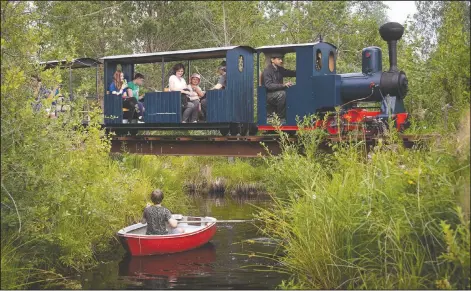  ?? (AP/Dmitri Lovetsky) ?? A miniature steam train runs across a bridge on Pavel Chilin’s miniature personal narrow-gauge railway twisting through the grounds of his home outside St. Petersburg, Russia.