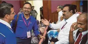  ?? PIC BY HASIYASYAH SABUDIN ?? BN candidate for Sri Tanjung seat R. Thinalan (second from left) speaking to his opponent M. Ravi Manusamy (second from right) of PKR in Port Dickson yesterday.