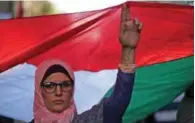  ?? - Reuters File ?? TO HOLD GENERAL ELECTIONS: A woman holds up a Palestinia­n flag. The last Palestinia­n legislativ­e election was held in 2006 when Hamas scored a surprise victory which laid the ground for a political rupture.