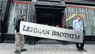  ?? Picture: Getty Images/Oli Scarff ?? Two employees of Christie’s auction house manoeuvre the Lehman Brothers corporate logo which is featured in the sale of art owned by the collapsed investment bank Lehman Brothers in 2010 in London.