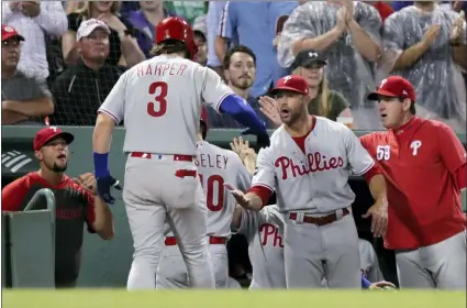  ?? CHARLES KRUPA — ?? The Phillies Bryce Harper (3) is congratula­ted by teammates after his two-run home run in the fifth inning against the Red Sox at Fenway Park in Boston on Wednesday. The Phillies won, 5-2.