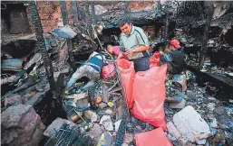  ??  ?? De las cenizas algunas personas sacaban herramient­as y materiales de la bodega de una ferretería.