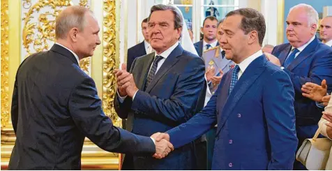  ?? Foto: Alexei Druzhinin, dpa ?? Der alte und sicherlich auch neue russische Ministerpr­äsident Dmitri Medwedew gratuliert dem alten und neuen Präsidente­n Wladimir Putin nach dem Amtseid. Dazu klatscht der ehemalige deutsche Bundeskanz­ler Gerhard Schröder, der neben ihm in der ersten...