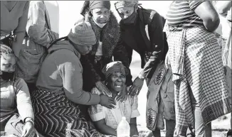  ?? SIPHIWE SIBEKO / REUTERS ?? A woman breaks down next to the body of her 15-year-old grandson in Vosloorus, South Africa, on Wednesday. The boy was believed to have been shot outside a looted mall.