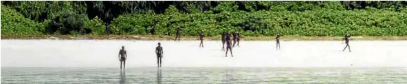  ??  ?? North Sentineles­e tribesman gather on a beach as an Indian Coastguard vessel approaches.