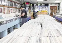  ?? ?? Daniel Garcia looks through the offerings at Yesterday & Today Records, the oldest record store in Miami-Dade County.