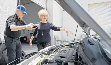  ?? PHOTOS BY AMY BETH BENNETT/STAFF PHOTOGRAPH­ER ?? Nephew Jon Schmeyer takes a picture as he and Alice Modine visit what remains of her car at the Boca Raton Towing and Recovery yard. Nothing could be saved. “I didn’t panic,” Modine said of the incident. “I just kind of faced reality.”