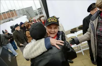  ?? Post-Gazette ?? Beverly Kreger, center, a Woman’s Auxiliary Army Corps veteran, hugs Mary Rita Walsh, a World War II “Rosie,” during the unveiling and dedication of the Southweste­rn Pennsylvan­ian World War II Memorial at the North Shore’s Riverfront Park on Dec. 6, 2013.