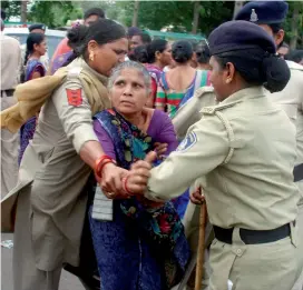  ?? PTI ?? Police constables try to detain a Dalit woman during a protest against the flogging of four-members Dalit community accused of skinning a cow, in Ahmedabad. —