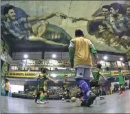  ?? JUAN MABROMATA / AFP ?? Kids play indoor soccer at the Sportivo Pereyra de Barracas club in Buenos Aires, which features Lionel Messi and Diego Maradona painted into a unique version of Michelange­lo's ‘Creation of Adam’ on the ceiling.