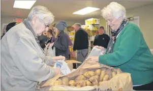  ?? JEREMY FRASER/CAPE BRETON POST ?? Ruby Pye, right, and Pencie Granchelli place potatoes in a bag in preparatio­n for distributi­on as part of the annual Combined Christmas Cheer program at the Sydney Mines Food Bank, Tuesday. This year’s program will serve about 250 families and includes...