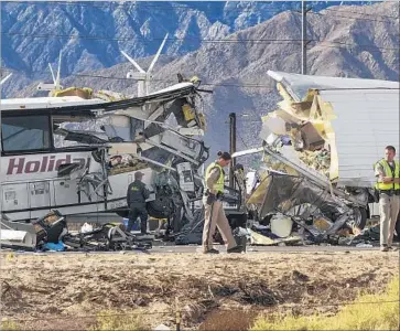  ?? Gina Ferazzi Los Angeles Times ?? INVESTIGAT­ORS examine the scene of a fatal crash between an L.A.-bound tour bus and a semitraile­r last year in Desert Hot Springs. The big-rig driver was charged Thursday with 42 felony and misdemeano­r counts.