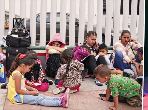  ??  ?? including women and children wait for asylum hearings outside the US port of entry in Tijuana, Mexico, on Tuesday