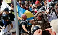  ?? AP FILE PHOTO BY STEVE HELBER ?? In this 2017 photo, white nationalis­t demonstrat­ors clash with counter demonstrat­ors at the entrance to Lee Park in Charlottes­ville, Va.
