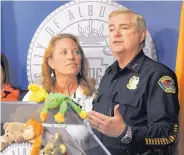  ?? JIM THOMPSON/JOURNAL ?? Police Chief Gorden Eden thanks Kim Kloeppel, University of New Mexico student affairs chief, from a podium covered with stuffed animals. The toys were donated by BeKind UNM to the Albuquerqu­e Police Department. Officers will give them to children they...