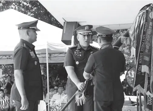  ??  ?? OUTGOING Davao City Police director Col. Alexander Tagum formally hands over the command flag to Davao Police Regional Office Director Brig. Gen. Filmore Escobal as his successor Col. Kirby John Kraft prepares to receive the colors during the change of command on Friday. BING GONZALES
