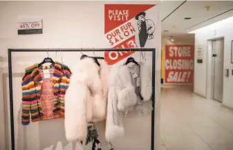  ?? Photos by Stephen Speranza / New York Times ?? Fur coats hang near a sale sign at Barneys in New York. Below: Many of the pedestals for items are already empty. Barneys’ remaining stores are expected to close by the end of February.