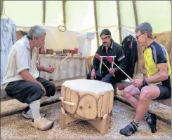  ?? LAWRENCE POWELL ?? Acadian interprete­r Wayne Melanson, Mi’kmaq interprete­r and drummer Robbie McEwan, and visitor Marty Daignault from Boston take part in the drumming for the Gathering Song, which McEawn sang inside the wigwam at the Habitation in Port Royal recently. Daignault, coincident­ly, was born on Lake Champlain.