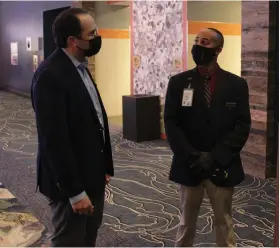  ?? (Pine Bluff Commercial/Dale Ellis) ?? Carlton Saffa (left) talks with Sedearius Litzseg, a security official with Saracen Casino Resort, at the temperatur­e check station that all patrons must pass through for screening before entering the gambling floor.