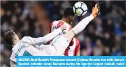  ??  ?? MADRID: Real Madrid’s Portuguese forward Cristiano Ronaldo vies with Girona’s Spanish defender Jonas Ramalho during the Spanish League football match between Real Madrid CF and Girona FC at the Santiago Bernabeu stadium in Madrid on Sunday. — AFP