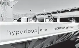  ?? David Becker Getty Images ?? HYPERLOOP ONE will soon be called Virgin Hyperloop One. Above, people look at a demostrati­on test sled after a 2016 test of the propulsion system in Nevada.