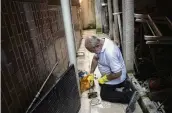  ?? BRUNA PRADO / AP ?? Augusto Cesar, a city worker who combats endemic diseases, pours larvicide down a home’s drain where mosquitoes can breed in the Morro da Penha favela of Niteroi, Brazil, on March 1.