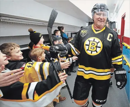  ?? CLIFFORD SKARSTEDT EXAMINER ?? Ray Bourque of the Boston Bruins Alumni greets young hockey players during a break against the Norwood Hornets Alumni on Saturday.