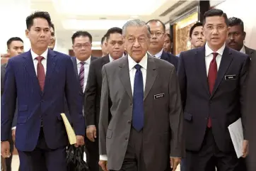 ??  ?? Dr Mahathir (centre) with Azmin (right) arrive for the sitting in Parliament. — Bernama photo