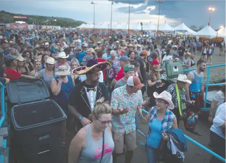  ?? BRANDON HARDER FILES ?? Fans leave the main stage area after being asked to take cover due to lightning during the Country Thunder music festival.