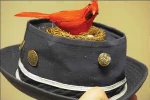  ?? SUBMITTED PHOTO ?? This navy canvas pork pie hat boasts a cardinal perched in its nest and is encircled with coins and metal buttons.