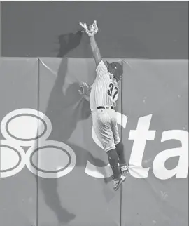  ?? Mitchell Leff Getty Images ?? CENTER FIELDER Odubel Herrera makes a catch against the wall on a ball hit by Yasiel Puig to end the game and hand the Dodgers their 20th loss in 25 games.