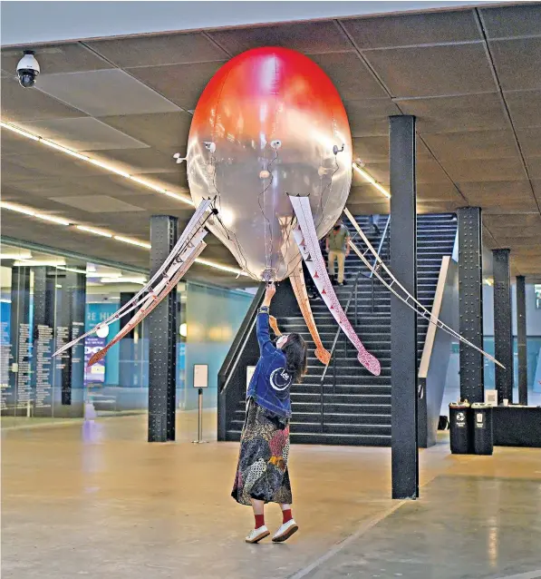  ?? ?? A technician at Tate Modern in London adjusts an ‘aerobe’, a helium-filled floating machine that responds to its environmen­t as part of the Hyundai Commission, undertaken by the artist Anicka Yi
