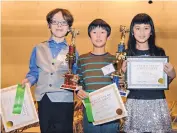  ??  ?? The top three finishers of the APS Spelling Bee on Thursday were: Garrick Tam, center, of Hawthorne Elementary, in first place; Benjamin Ramsey, left, from Monte Vista Elementary, in second; and Katie Tran, third place, of Petroglyph Elementary.