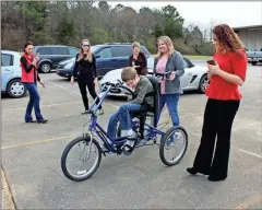  ?? / Alexis Draut ?? Zachary Cagle, 10, who was just given a custom bike by Freedom Concepts, celebrates by riding around the parking lot at Advance for Kids.