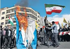  ?? ?? An Israeli flag is burnt in Tehran following an alleged air strike on the Iranian embassy