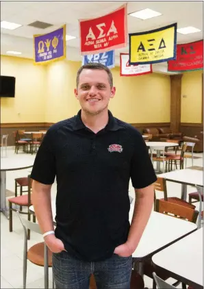  ?? MARK BUFFALO/TRILAKES EDITION ?? Keith Beason, standing in a dining area adorned with Greek-life symbols at Henderson State University, recently completed his first year as director of Greek life at the Arkadelphi­a college. Beason, a native of Redwater, Texas, is a 2009 graduate of...