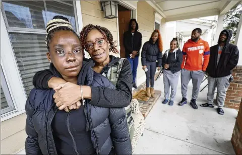  ?? PHOTOS BY MIGUEL MARTINEZ/MIGUEL.MARTINEZJI­MENEZ@AJC.COM ?? Tonya McElrathbe­y embraces daughter Brittany during a family reunion as Brittany’s siblings gather around. Family members said they felt they were on their own when Brittany was shot in January and several of them who called 911 were put on hold.