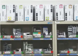  ??  ?? MEDICINES on a shelf of a prescripti­on pharmacy is seen through its window in Tokyo, Japan, Dec. 20, 2016.