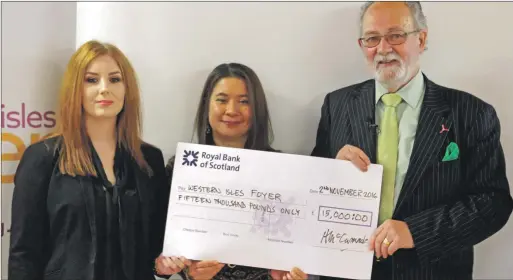  ??  ?? Angus McCormack, chairman of Point and Sandwick Trust, presenting the cheque to Foyer project leader Rebecca Mahony, centre, and support worker Anna Campbell.