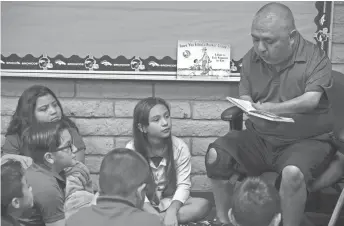  ?? MARK HENLE/THE REPUBLIC ?? David Solano reads “How to Kill a Monster” to his fourth-graders at Palm Lane Elementary School in Phoenix. The first day of every school year, Solano answers kids’ questions about his disability.