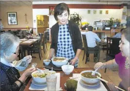  ??  ?? JULIE LAM tends to customers at her family’s Vien Dong restaurant in Orange County’s Little Saigon. Her uncle, Tony Lam, founded the eatery.