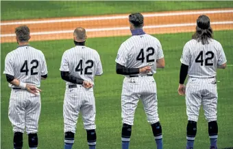  ?? Dustin Bradford, Getty Images ?? Rockies players, from left, Drew Butera, Trevor Story, Nolan Arenado and Charlie Blackmon stand and wear No. 42 in honor of Jackie Robinson Day on Friday night.