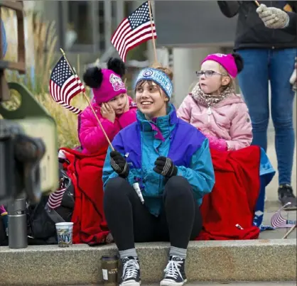  ?? Pam Panchak/Post-Gazette photos ?? Rosie Manly, 4, holds her ears while Gina Schratz, 17, and Lily Manly, 5, cheer their grandmothe­r and aunt — Col. Anne Manly with the 911th Airlift Wing — who marched in Saturday’s 100th annual Veterans Day parade.