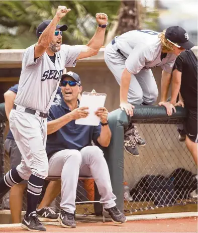  ?? Brett Coomer / Houston Chronicle ?? Head coach Lance Berkman, left, and assistant Andy Pettitte, seated, celebrate Second Baptist’s 7-2 win over Midland Christian for the TAPPS Class 4A state baseball championsh­ip at Baseball USA’s Mendel Field on Wednesday.