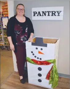  ?? TAMMY KEITH/THREE RIVERS EDITION ?? Melissa Allen, programs director for the Community Action Program for Central Arkansas, stands with a snowman box in Conway decorated by volunteers to collect donations for the food pantry that serves Faulkner County. A Deck the Box contest is being held in Faulkner, Cleburne and White counties to stock depleted food pantries. People can vote for their favorite boxes on the CAPCA Facebook page.