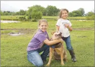  ?? LYNN KUTTER ENTERPRISE-LEADER ?? Maebree Whorton, 10, and her sister, Basilee Whorton, 5, stand with their dog, Rooster, on the family farm just outside Lincoln.